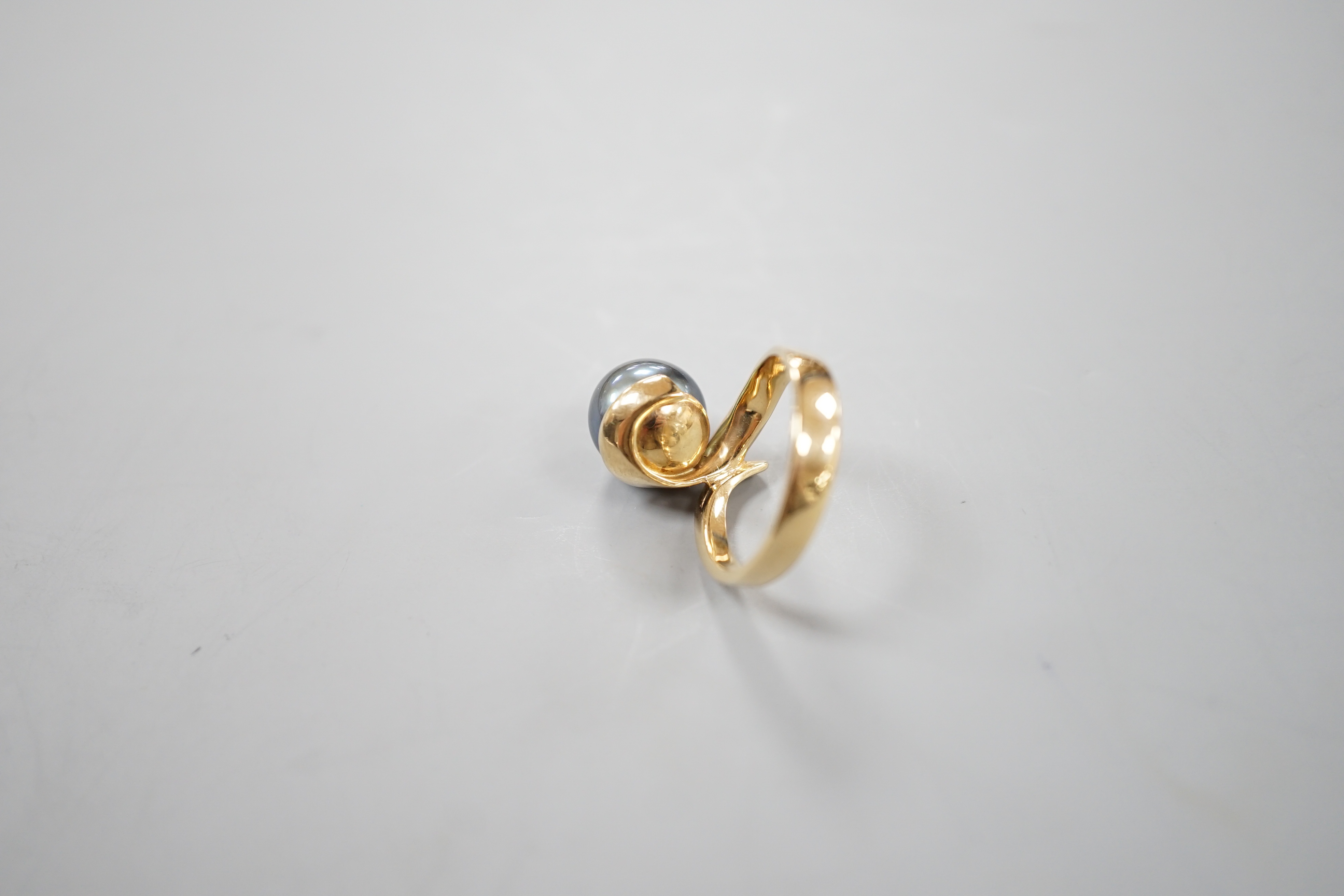 A modern 14k yellow metal and Tahitian pearl set ring, size O/P, gross 6.3 grams.